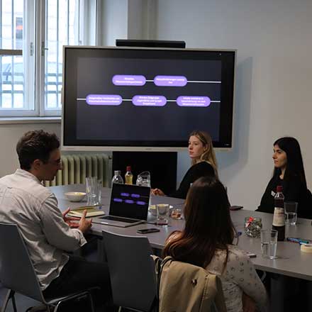 Foudning Lab mit Studierenden der Universität Wien, die an einem Tisch sitzen und diskutieren; Workshopsetting