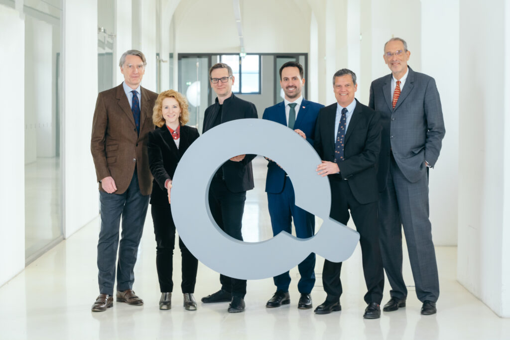 Sebastian Schütze, Eva-Maria Holzleitner, Christopher Lindinger, Christoph Wiederkehr, Jens Schneider, Heinz Faßmann halten ein Modell des Q-Logos in den Händen.